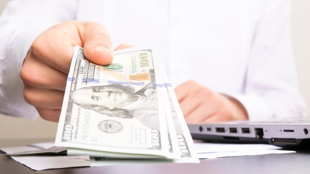 Man handing Inheritance Advance money in dollar bills