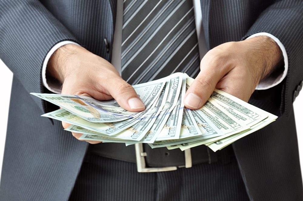 Man in suit holding Probate Loan cash